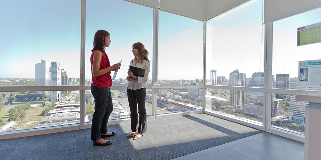 women talking in high-rise office building