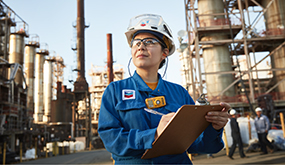 chevron worker in the field, holding a clipboard