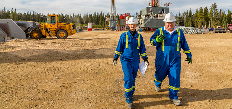 man and woman chevron employees walking through field