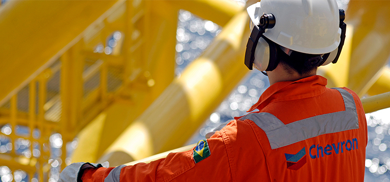 back of man wearing Chevron coveralls and hard hat