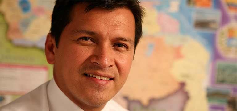 man smiling at camera in front of map