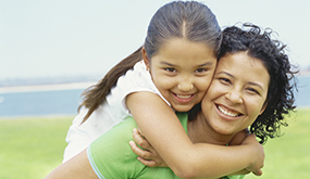 a girl holding on to woman on piggyback
