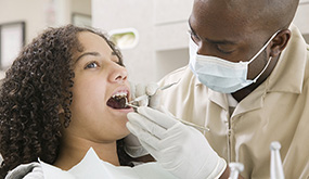 a woman having teeth checked at dentist office
