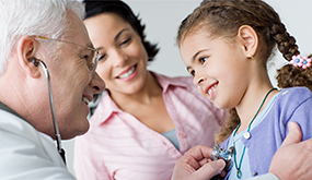 a doctor uses a stethoscope on a girl