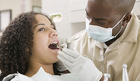 girl having her teeth checked by dentist
