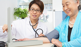 medical practitioner measuring woman's blood pressure