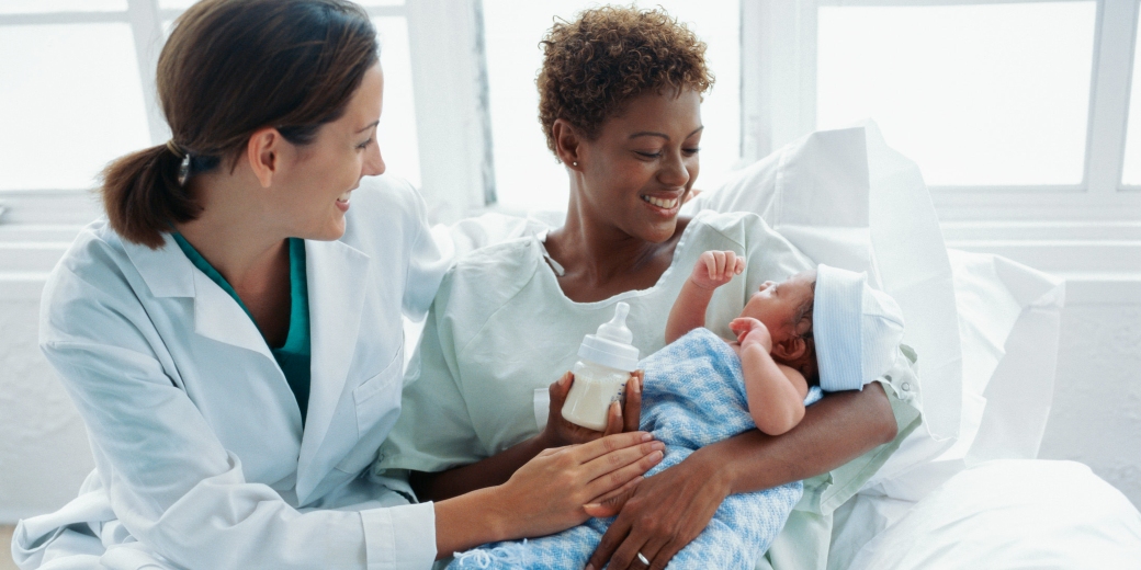 medical practitioner assisting patient with newborn baby