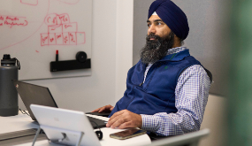 a man looking at laptop, attending a meeting remotely