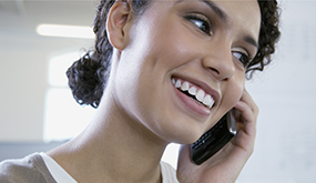 woman smiling while on mobile phone