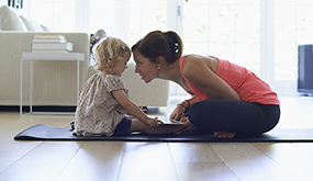 woman playing with child on floor