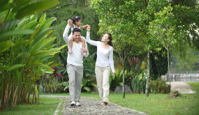 family walking on a sidewalk surrounded by greenery