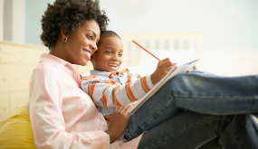 woman and child doing homework on her lap